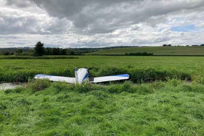 The Piper Cherokee aircraft in the River Axe where it was forced to land just minutes into a flight from Dunkeswell Aerodrome.