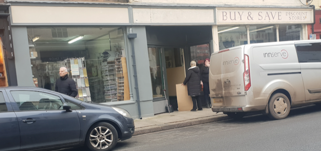 Cardboard screens were erected around an elderly woman as she waited hours for an ambulance which never arrived