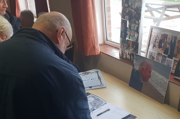 Mourners sign a book of memoriam in Wellington Rugby Club for Richard Fox.