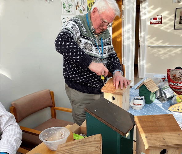 Putting the finishing touches to a bird nesting box in Nynehead Court.