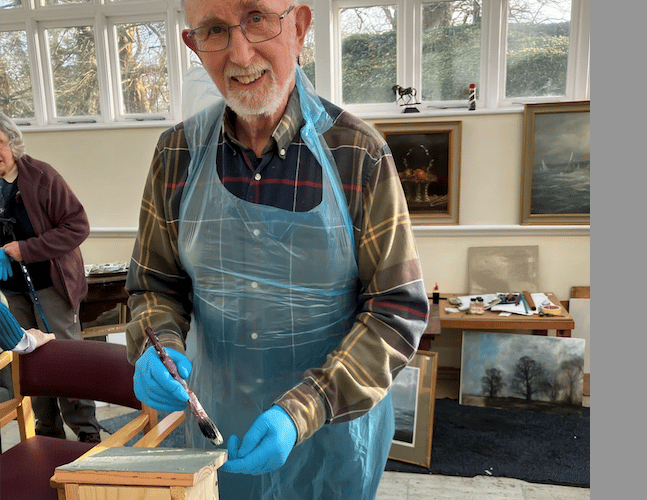 Putting a protective coat on the bird nesting boxes made by Nynehead Court residents.