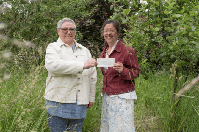 Diane Goring handing over money raised from Pop-Up Shop