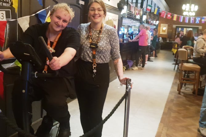 Wellington's Iron Duke team leader Ben Williams, watched by shift leader Kirsty Allen, takes a turn in a static cycle ride raising funds for Young Lives vs Cancer.