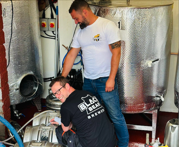 Brewer Tom Davis (kneeling) and pub group owner Jon Coward in their Wiveliscombe micro-brewery making the relaunched beer Black Bear Bitter.