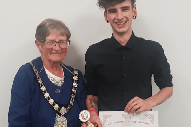 Wellington Mayor Cllr Janet Lloyd presenting Toby Brimacombe, of Odette's Tearoom, with the town council's 2024 business award.