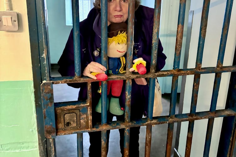 Reminiscence Learning CEO Fiona Mahoney, trying out a Shepton Mallet prison cell with the charity’s mascot Archie.