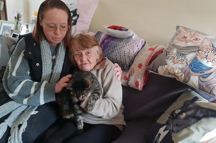 Lorraine Faber comforts her friend Sue Palk, who is holding her cat Stan.